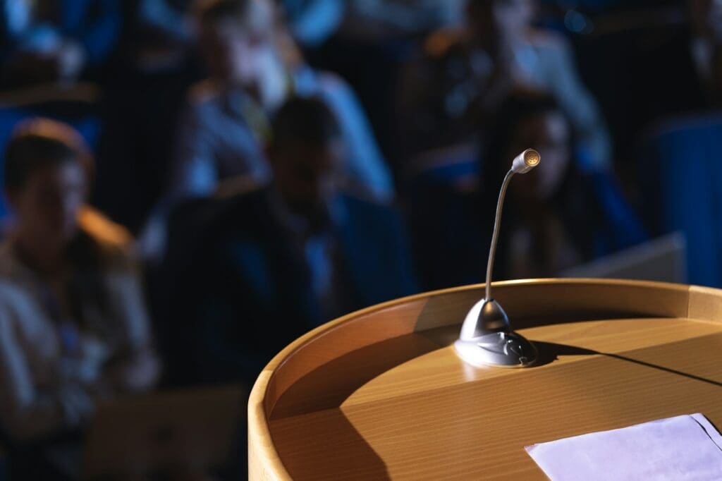 Close up of podium with speaker in auditorium